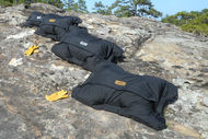 four fitness sandbags on rocks